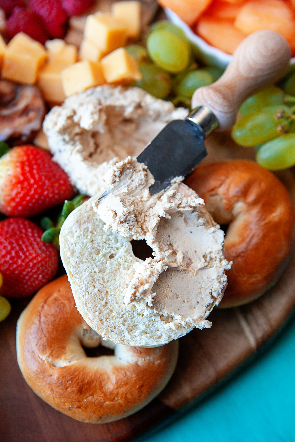 Spreading a bagel with cheese. 