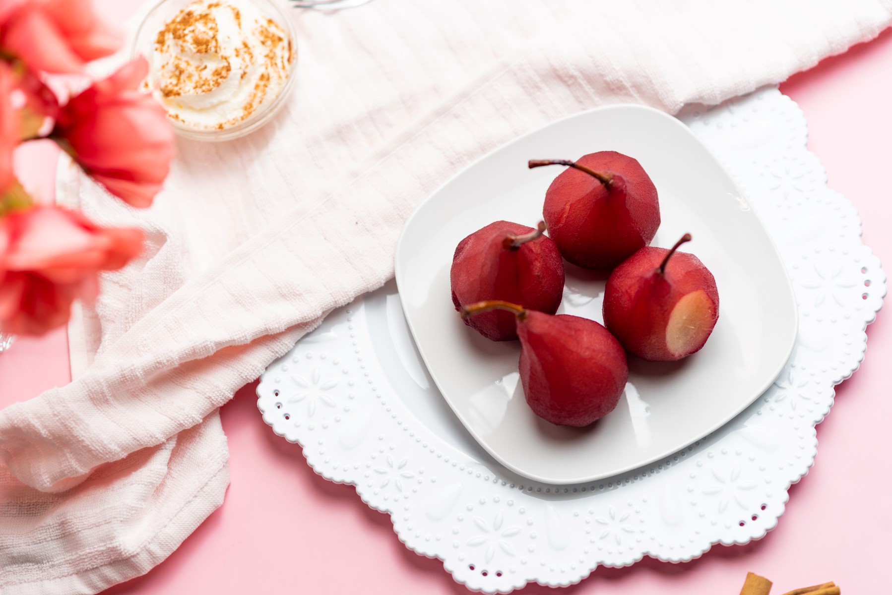 4 red wine poached pears on a white serving plate - horizontal. 