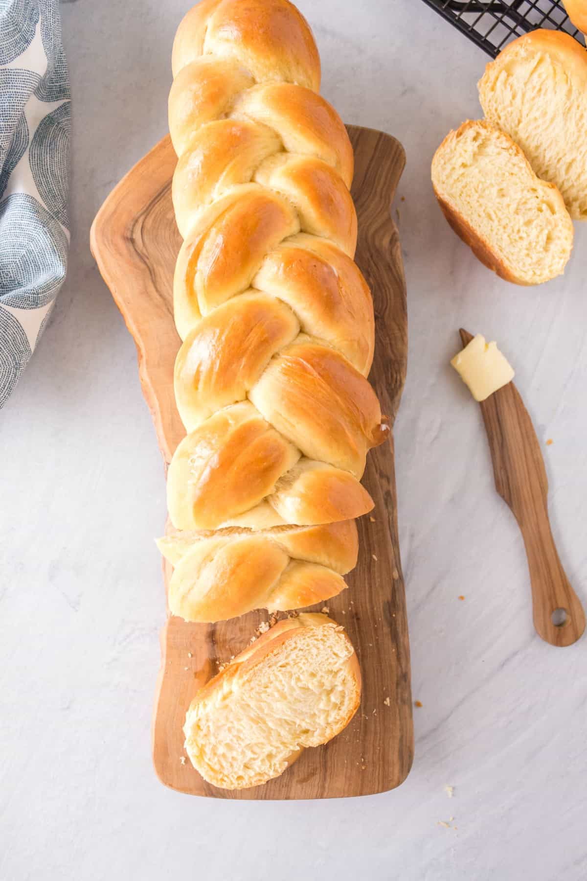 Overhead shot of white braided bread with some sliced. 