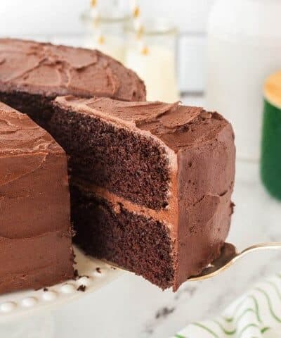 Taking a slice out of a chocolate layer cake.