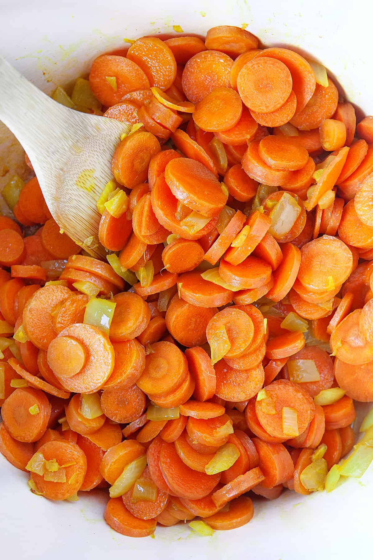 Overhead of carrots and onions cooking in a pot