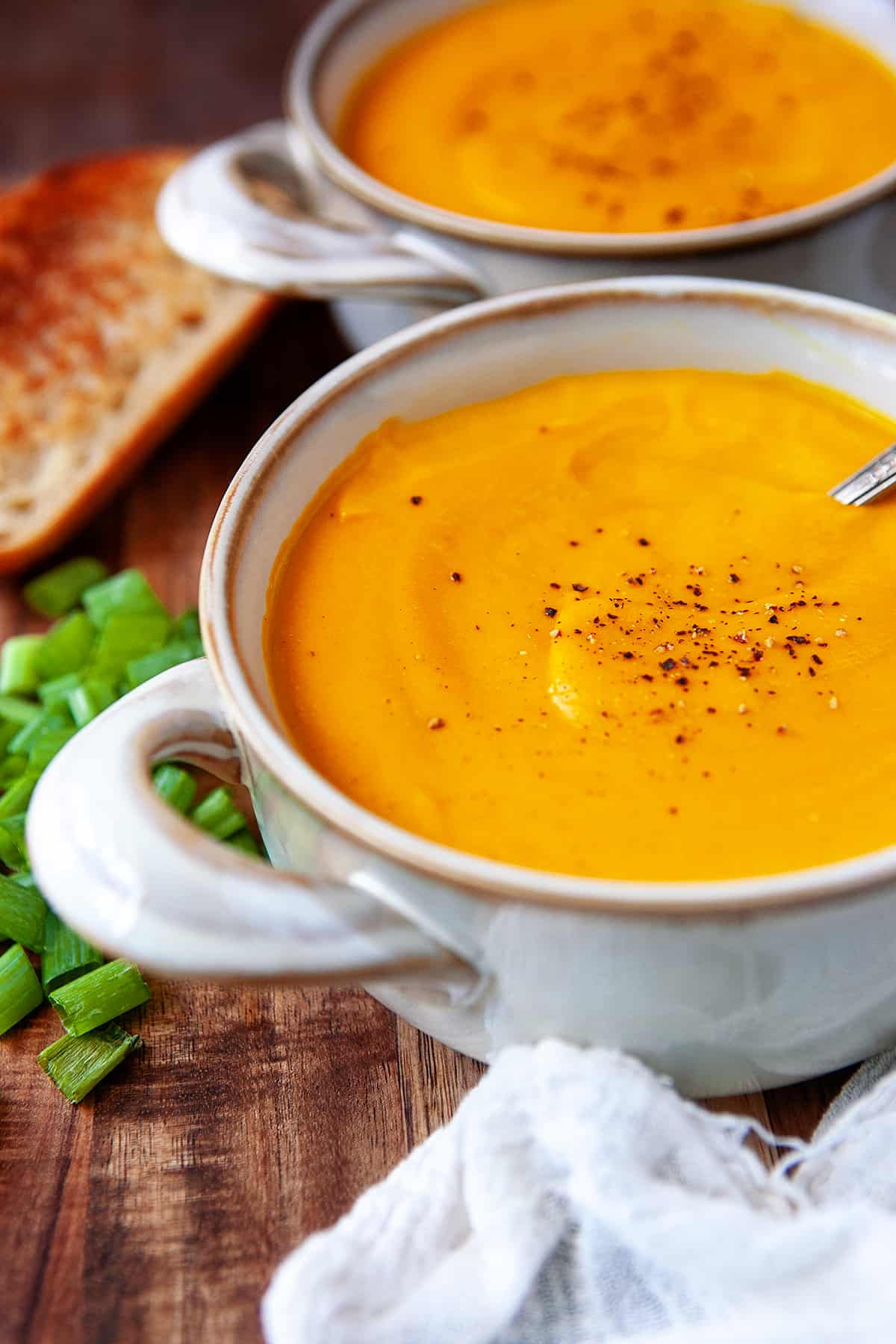 Two bowls of carrot ginger soup.