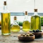 Bottle of olive oil with bowls of olives