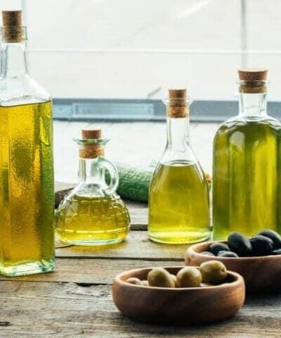 Bottle of olive oil with bowls of olives