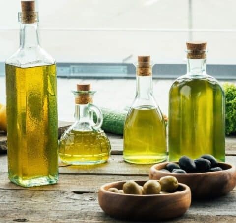 Bottle of olive oil with bowls of olives