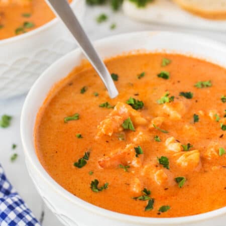 Lobster bisque in a bowl with a spoon.