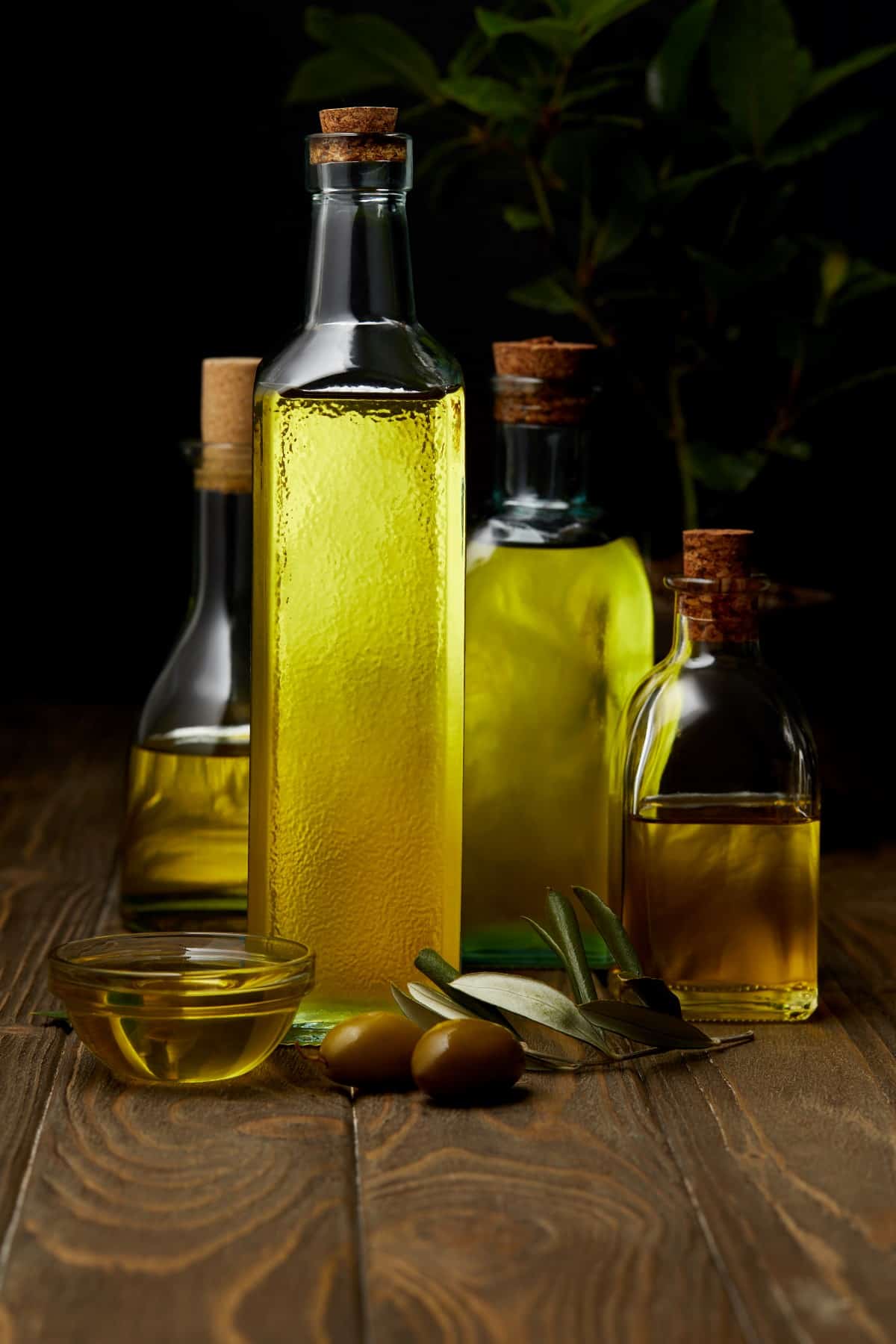 Bottles of various olive oil on wooden surface.