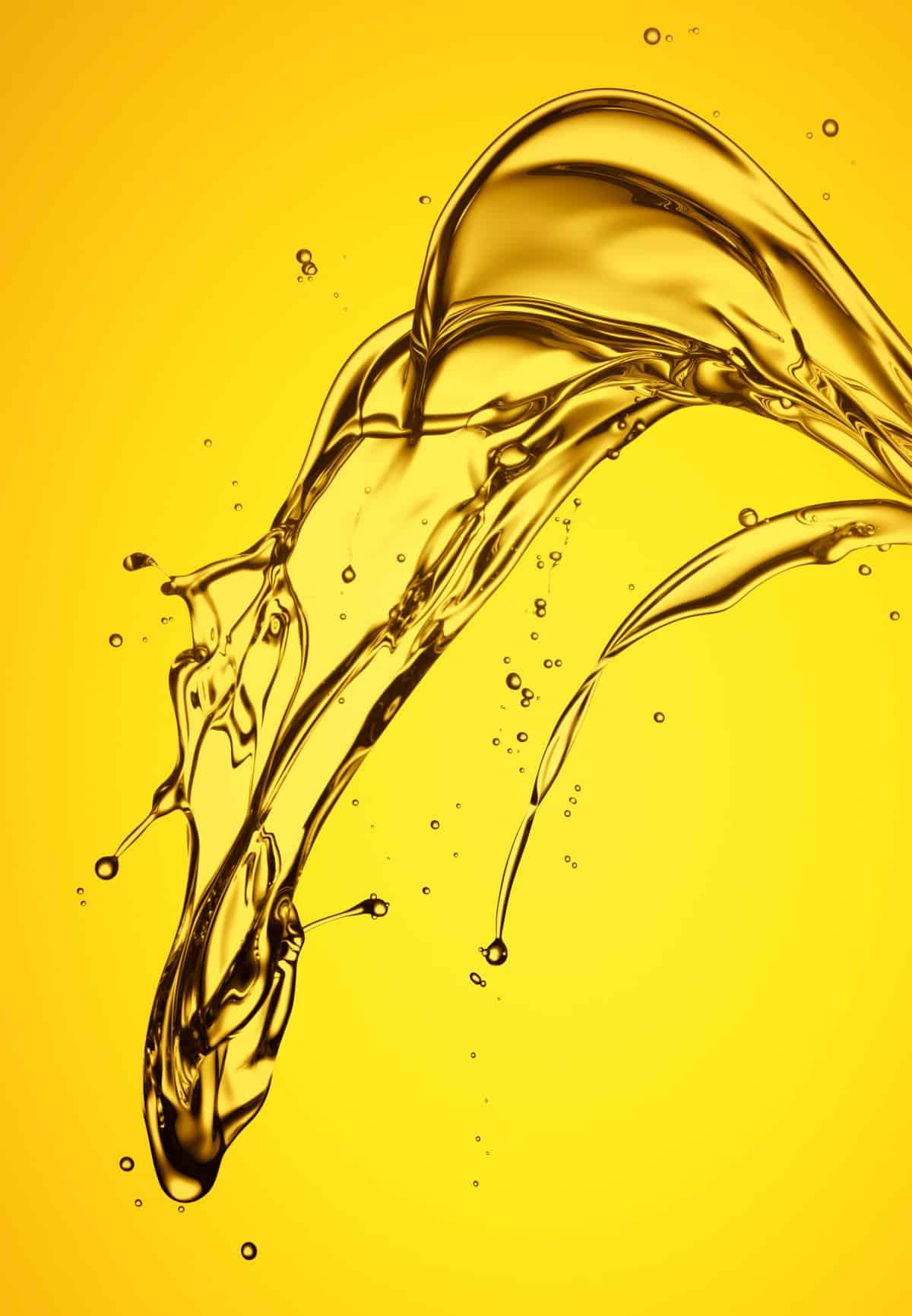gold color oil splashing against yellow background