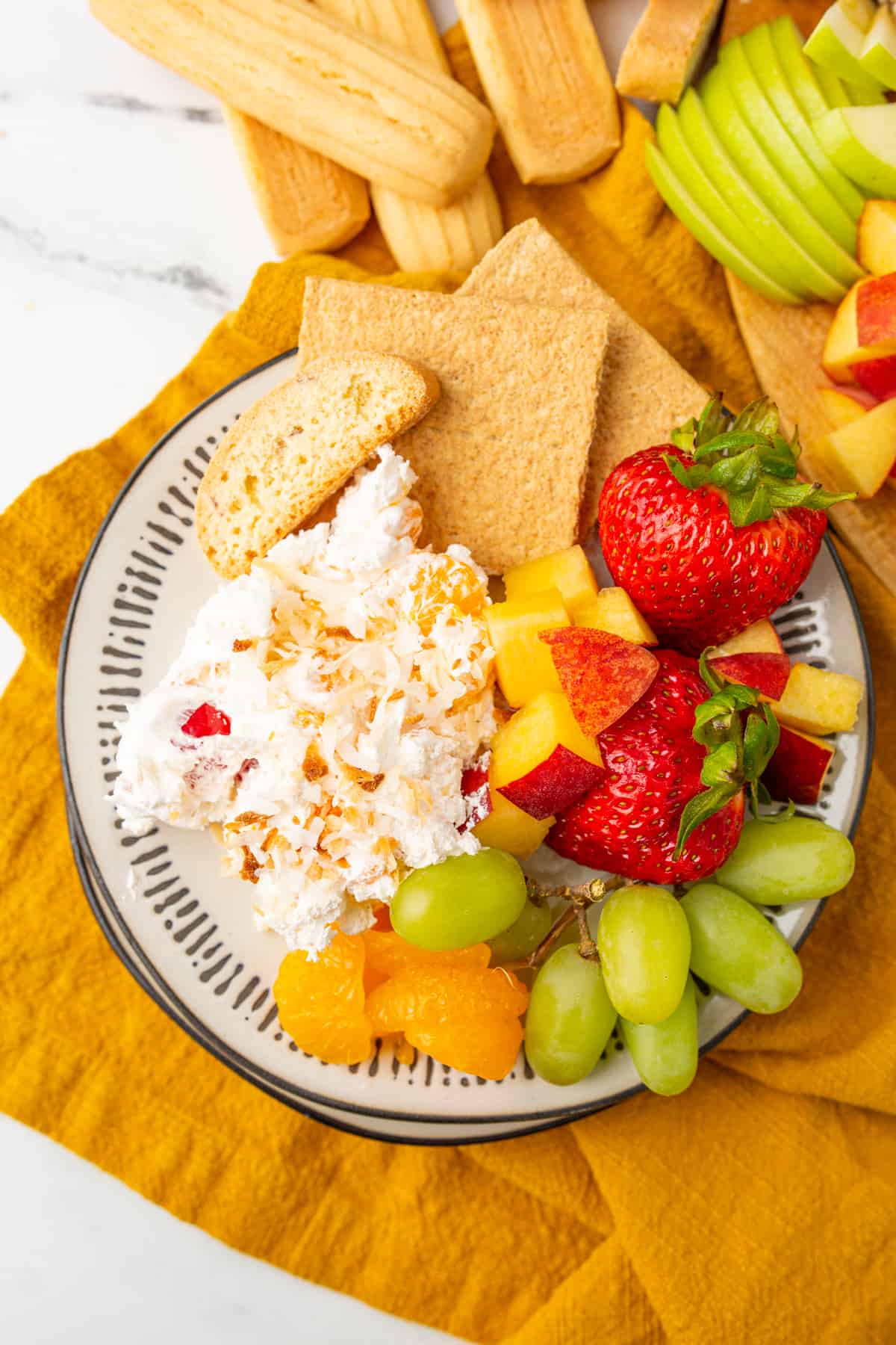 Pina Colada Fruit Dip - Fruit dip with coconut, cherries, mandarin oranges, and graham crackers for serving. 