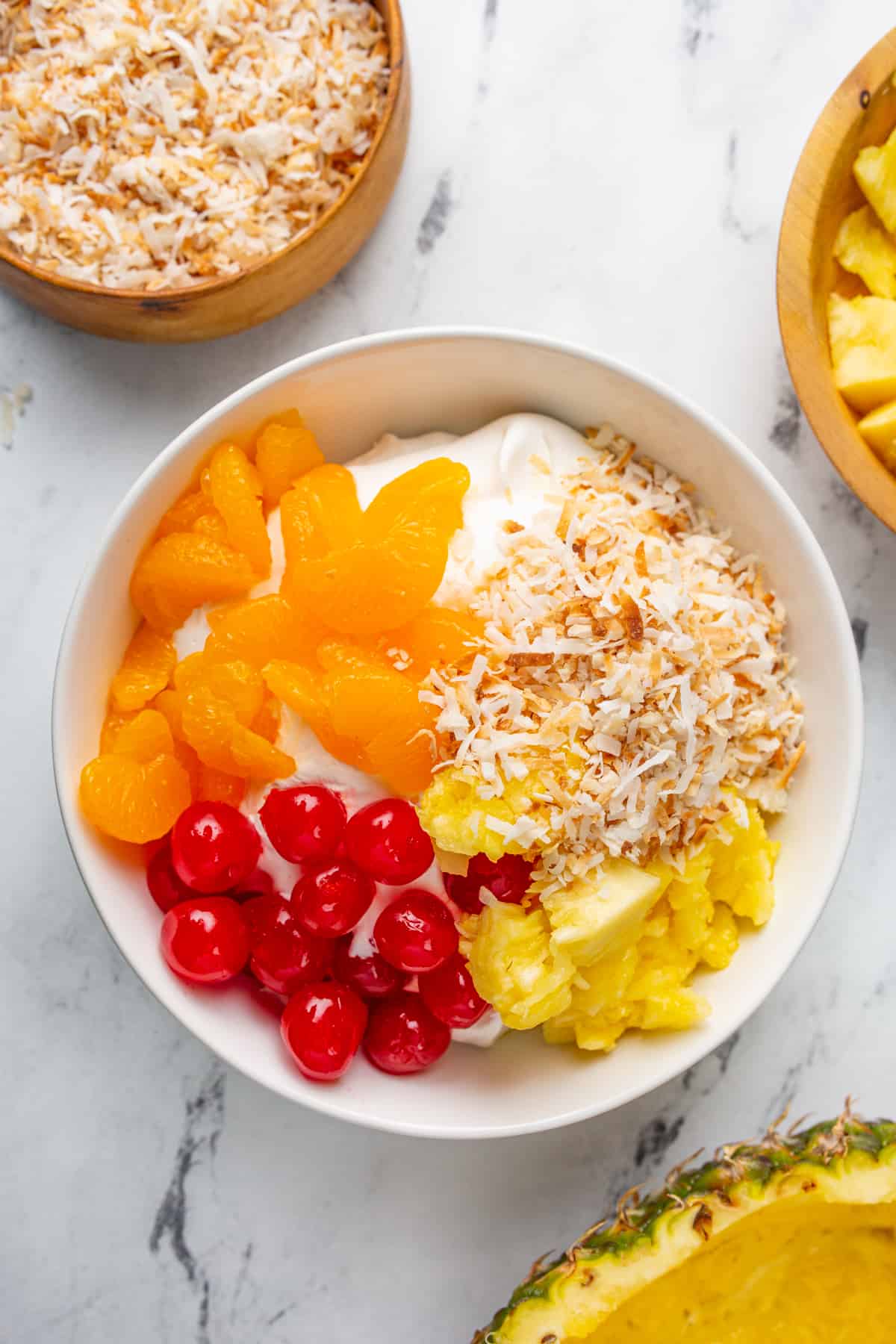 Easy Fruit Dip - Bowl of cool whip, oranges, cherries, pineapple chunks, and coconut. 