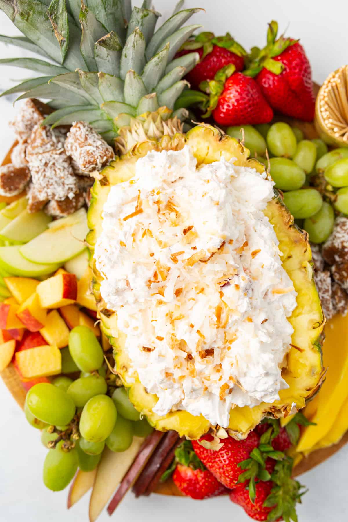 Easy Tropical Fruit Dip - pina colada dip filled in a halved pineapple topped with shredded toasted coconut