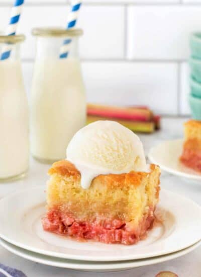 Old Fashioned Rhubarb Pudding Cake on a plate with a scoop of ice cream.