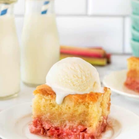 Old Fashioned Rhubarb Pudding Cake on a plate with a scoop of ice cream.