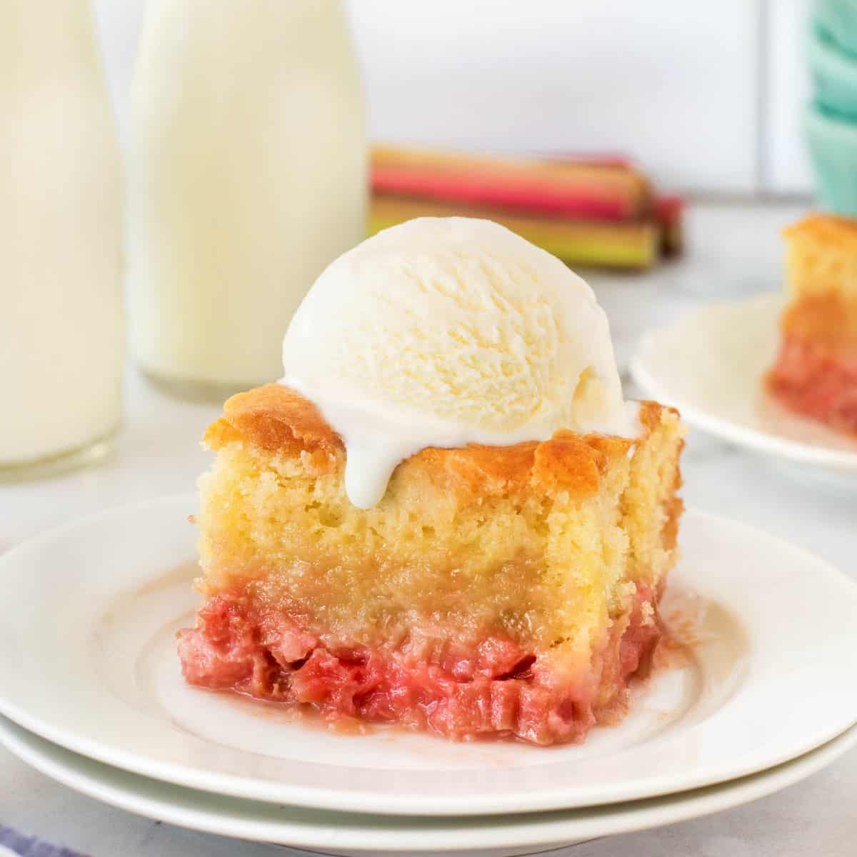 Old-Fashioned Rhubarb Pudding Cake on a plate with ice cream on top.