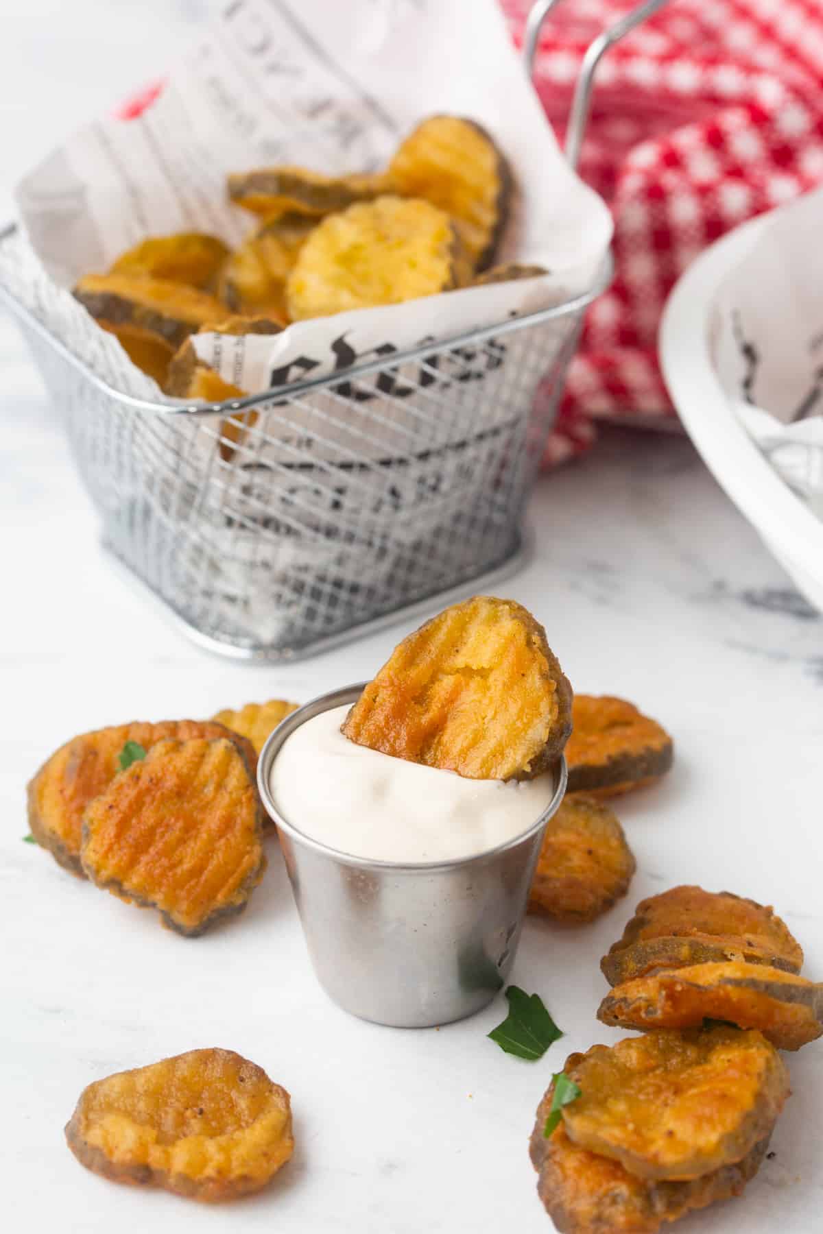 scattered deep fried bread and butter pickle chips on a table top