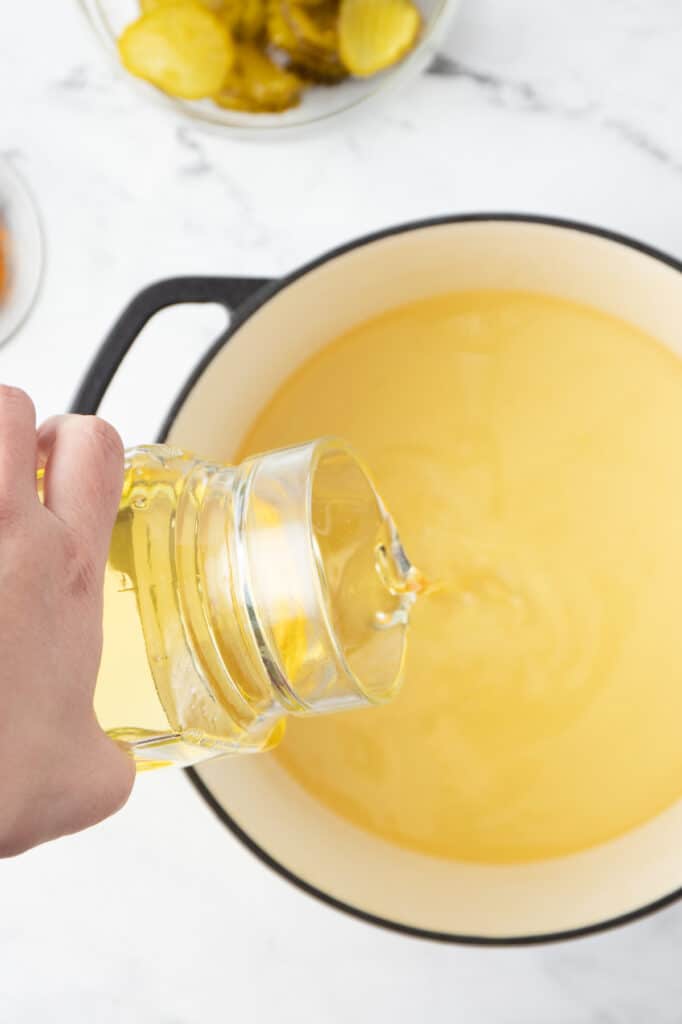 overhead image of pouring oil into a dutch oven