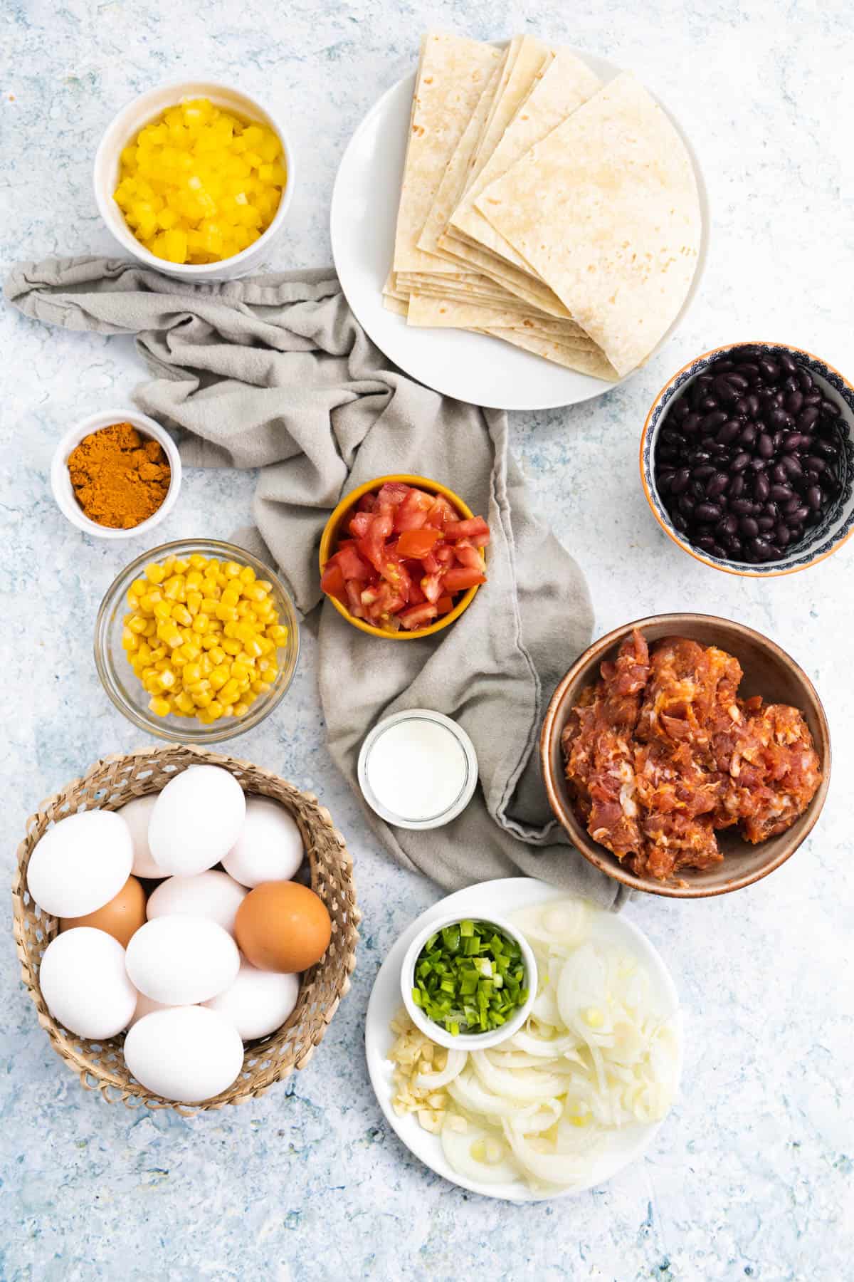Ingredients for a bake: tortillas, pepper, beans, tomato, meat, eggs, corn. 