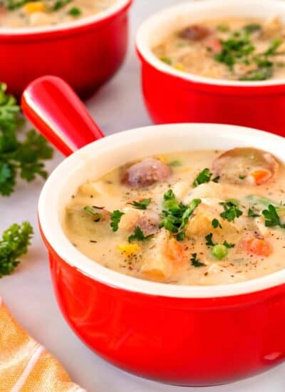 Red bowls of chicken potato soup.