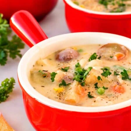 Red bowls of chicken potato soup.