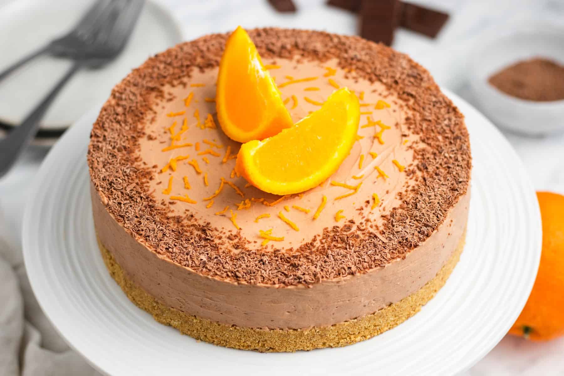 Horizontal photo of No-Bake Chocolate Cheesecake on a cake stand. 