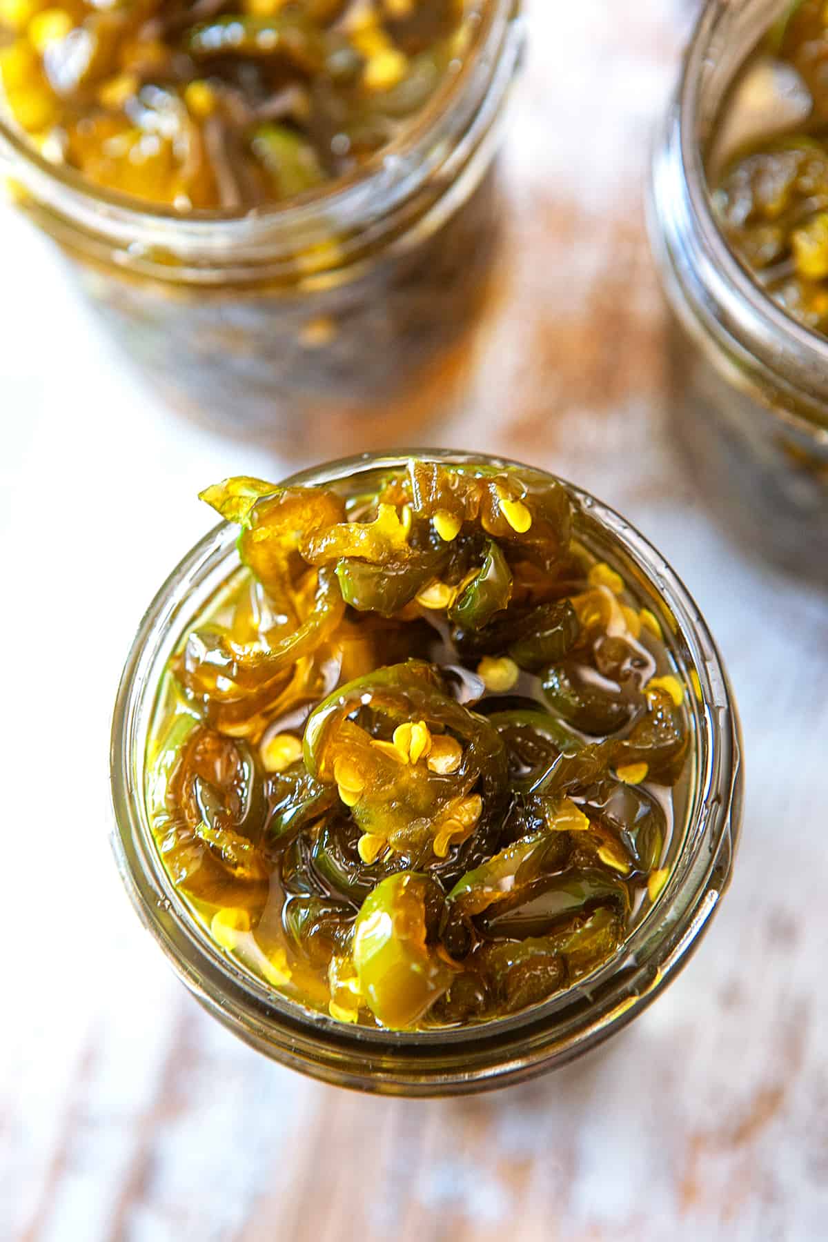 Overhead of candied jalapenos in a jar. 