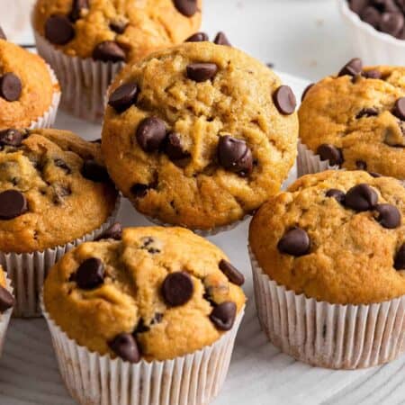 Banana Chocolate Chip Muffins on a cooling rack with one tilted forward.