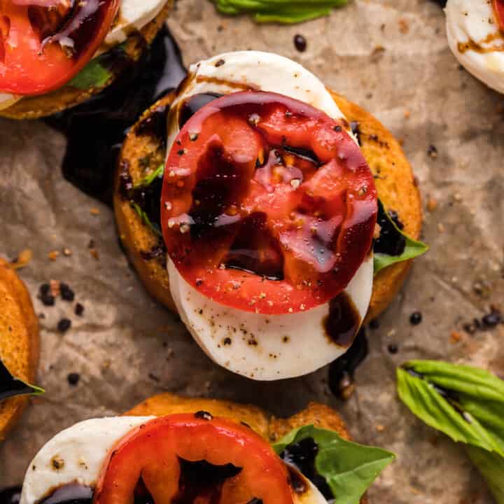 Overhead shot of Bruschetta Caprese on a parchment covered baking sheet