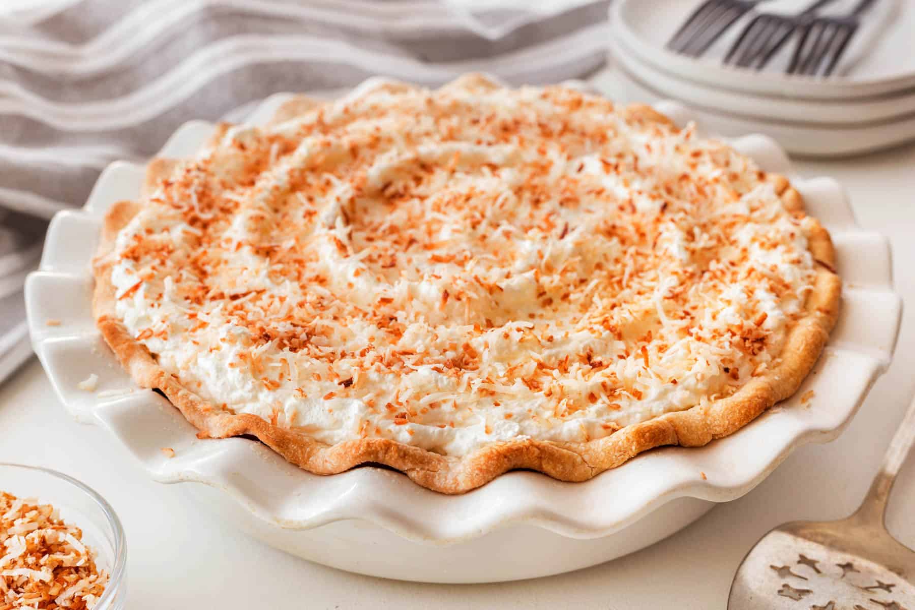 Finished coconut cream pie in a white pie plate. 