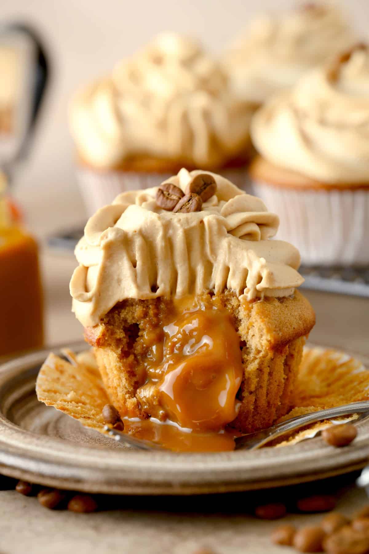 Close-up shot of caramel oozing out of a cut coffee cupcake. 