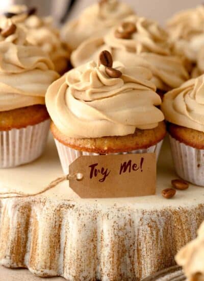 Coffee Cupcakes with Caramel Frosting and coffee beans on top with a sign that says try me.