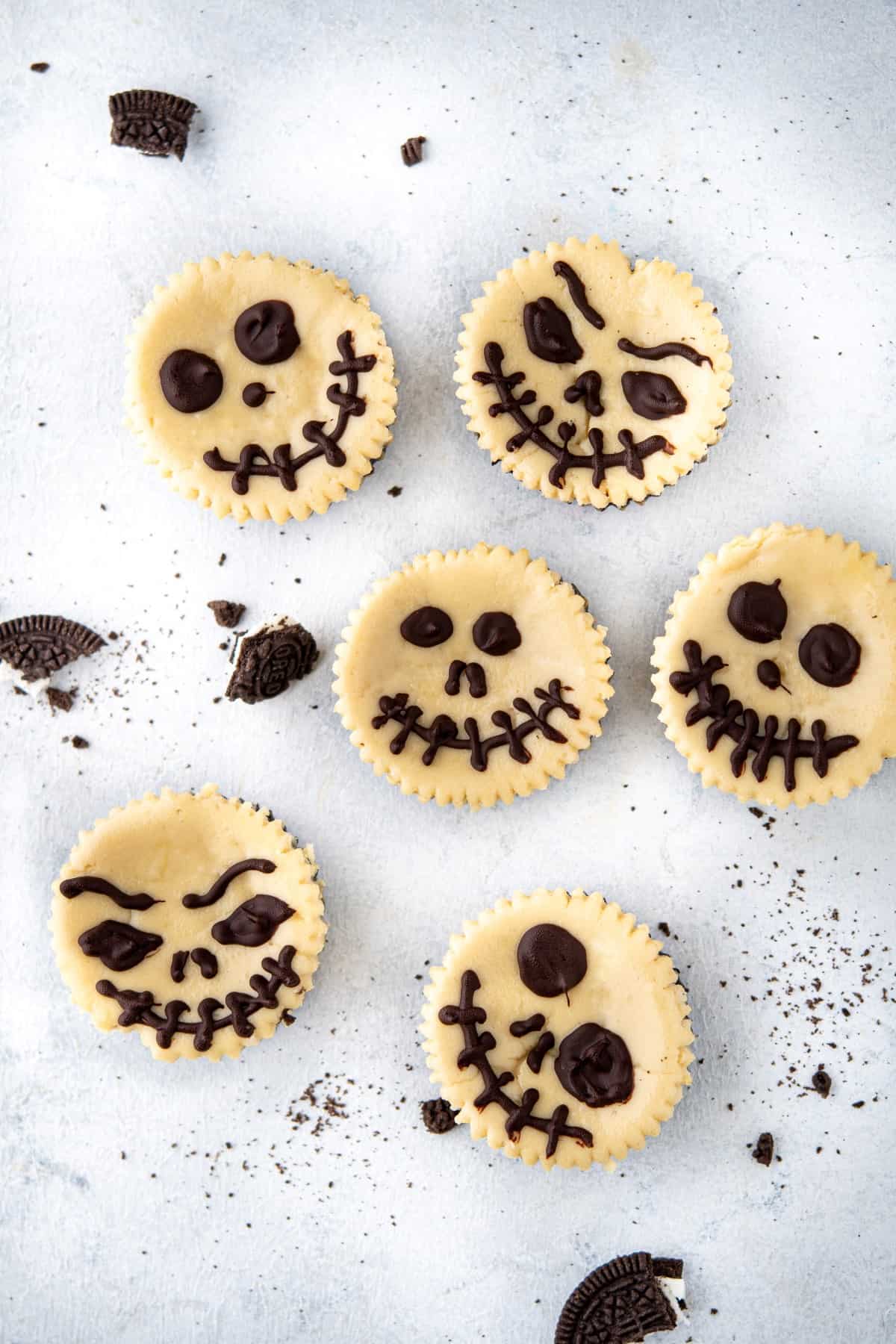 Overhead picture of Jack Skellington Halloween Cheesecakes with different faces. 