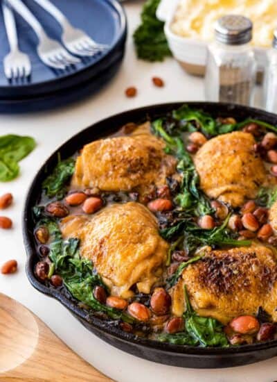 Close-up shot of Chicken Skillet with Beans and Greens in a cast iron pan.
