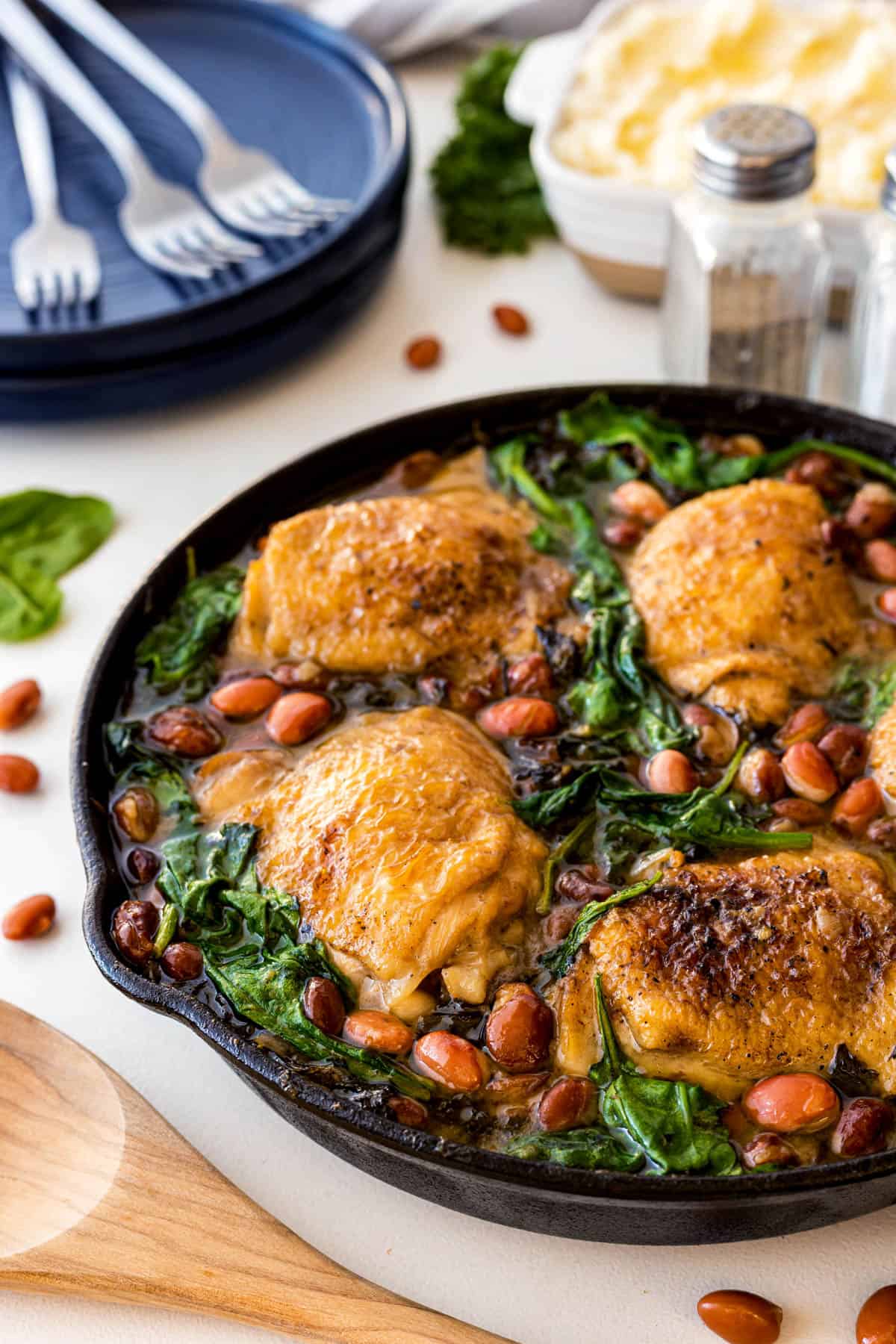 Close-up shot of Chicken Skillet with Beans and Greens in a cast iron pan. 