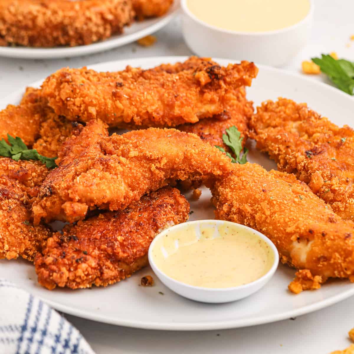 Cap'n Crunch Chicken Fingers on a plate with dipping sauce. 