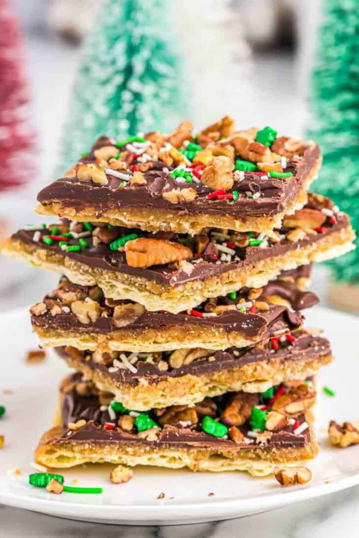 Christmas Crack pieces stacked up on a white plate.