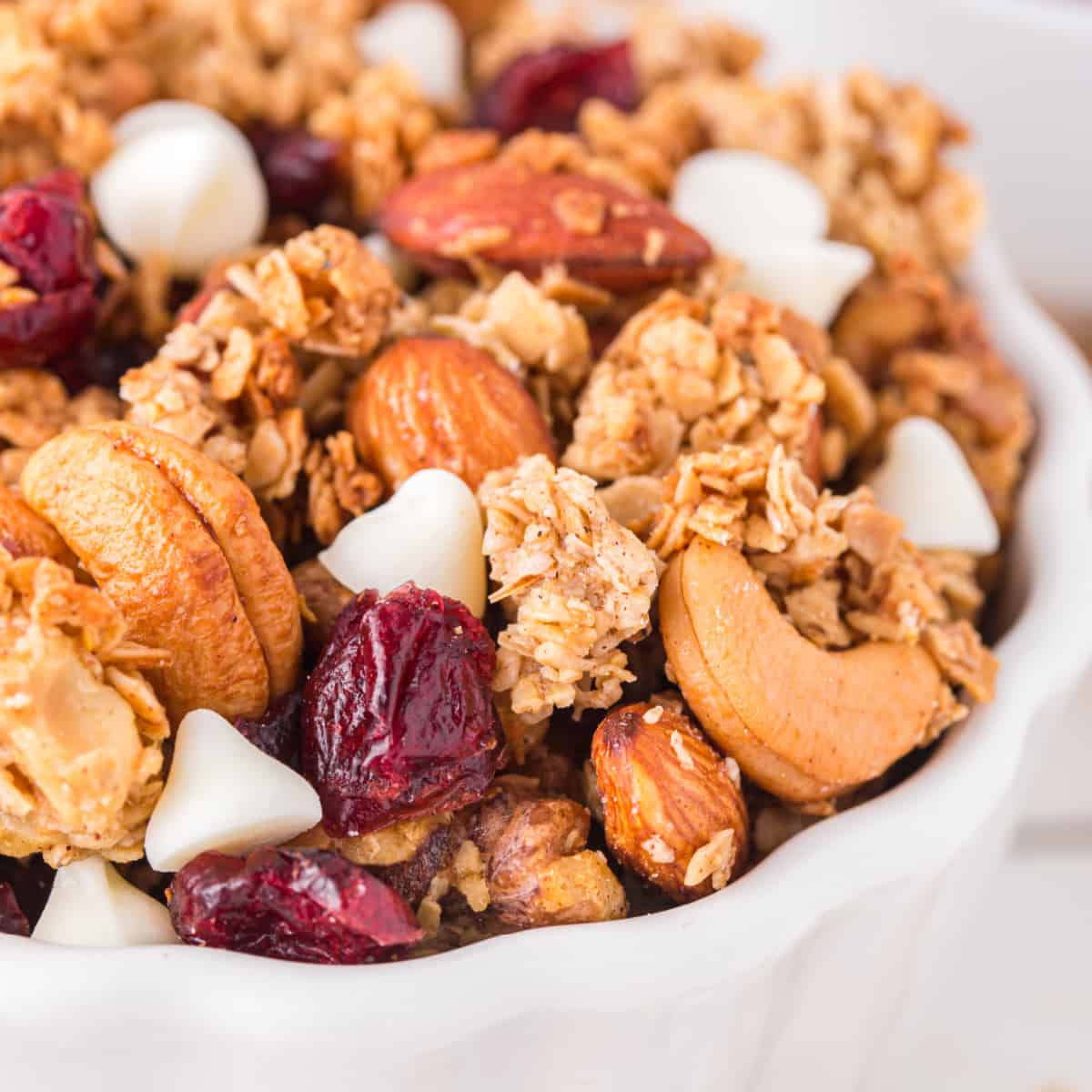 Close-up of granola in a white bowl, square image. 