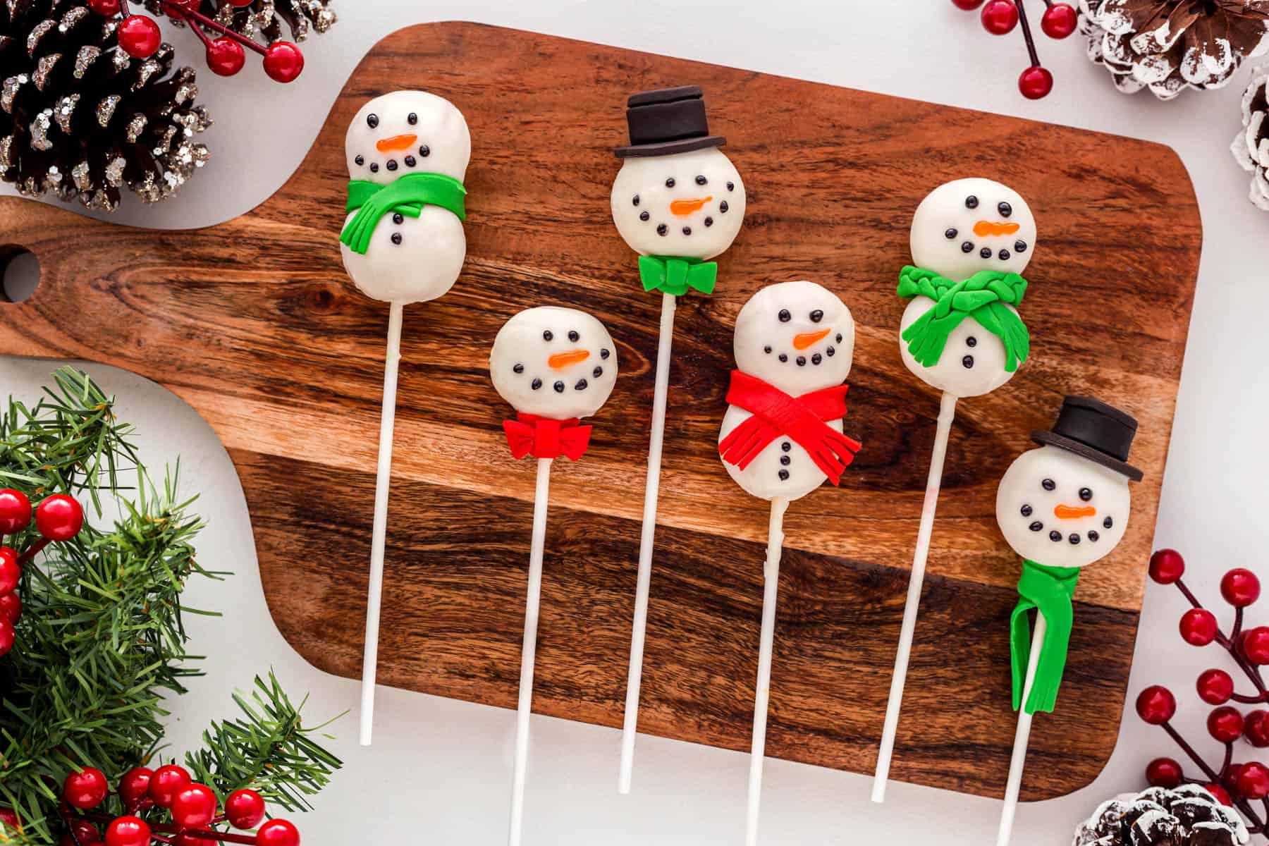 Snowman Cake Pops on a board in a horizontal picture. 