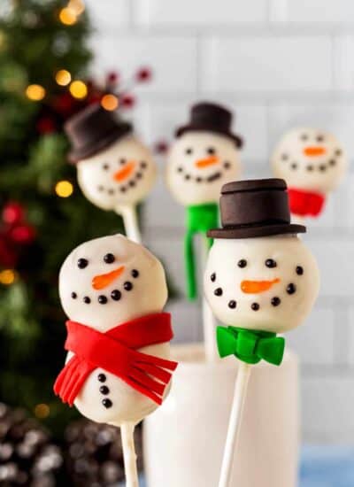 Two Snowman Cake Pops close-up with others in the background.