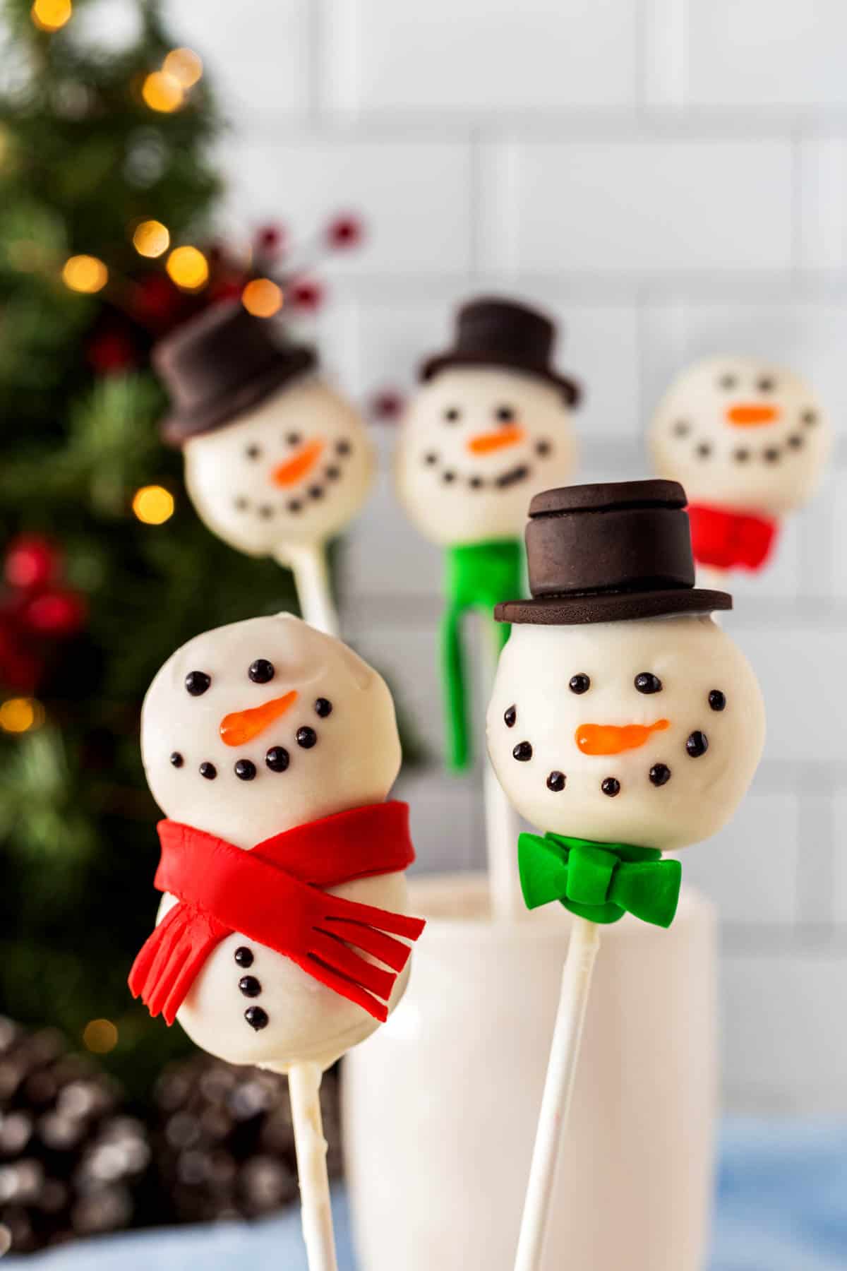 Two Snowman Cake Pops close-up with others in the background. 