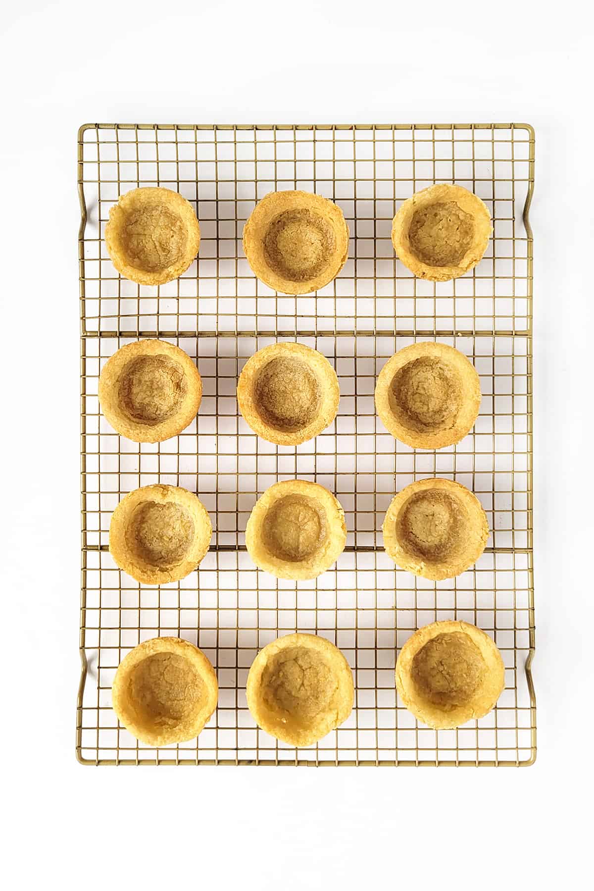 Overhead shot of baked cookie cups on a wire rack.