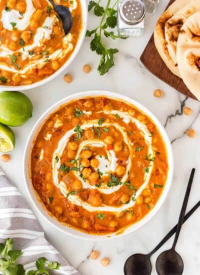 Bowls of chickpea curry with a spiral of sour cream or yogurt.