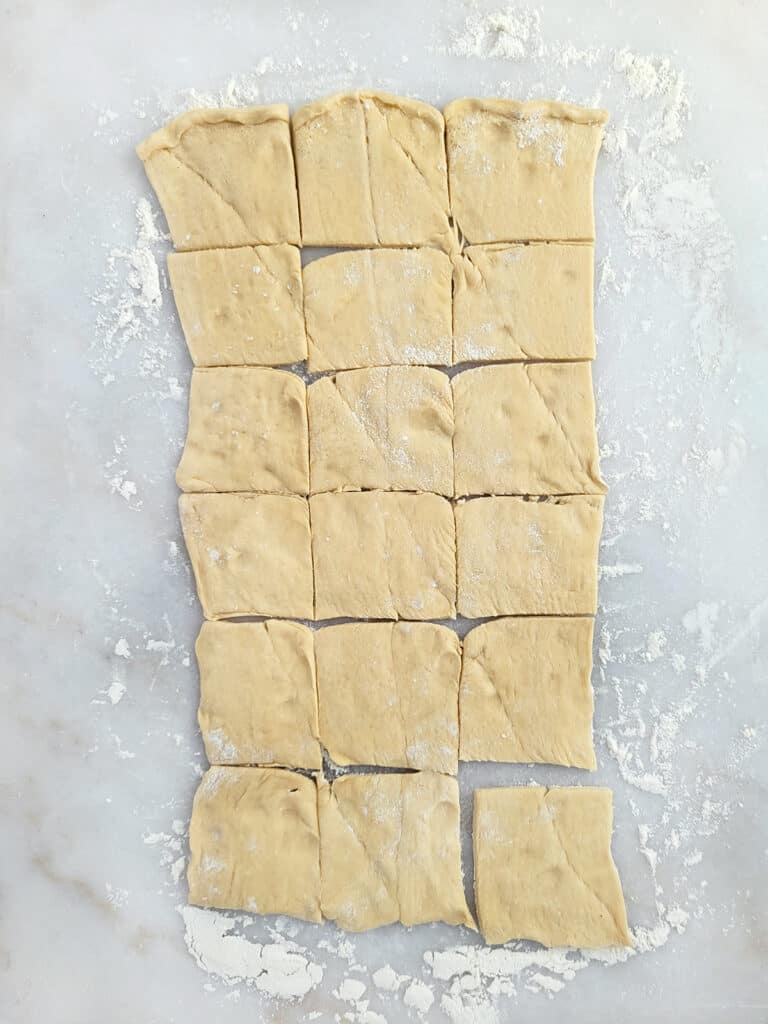 Crescent roll dough cut into squares. 