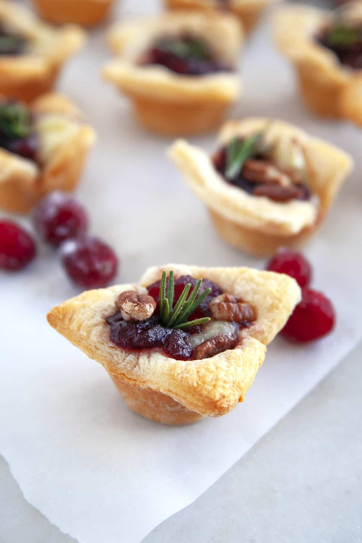  Close-up of cranberry brie appetizer. Garnished with a sprig of rosemary. 