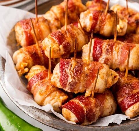 Metal plate filled with Bacon-Wrapped Chicken Bites.