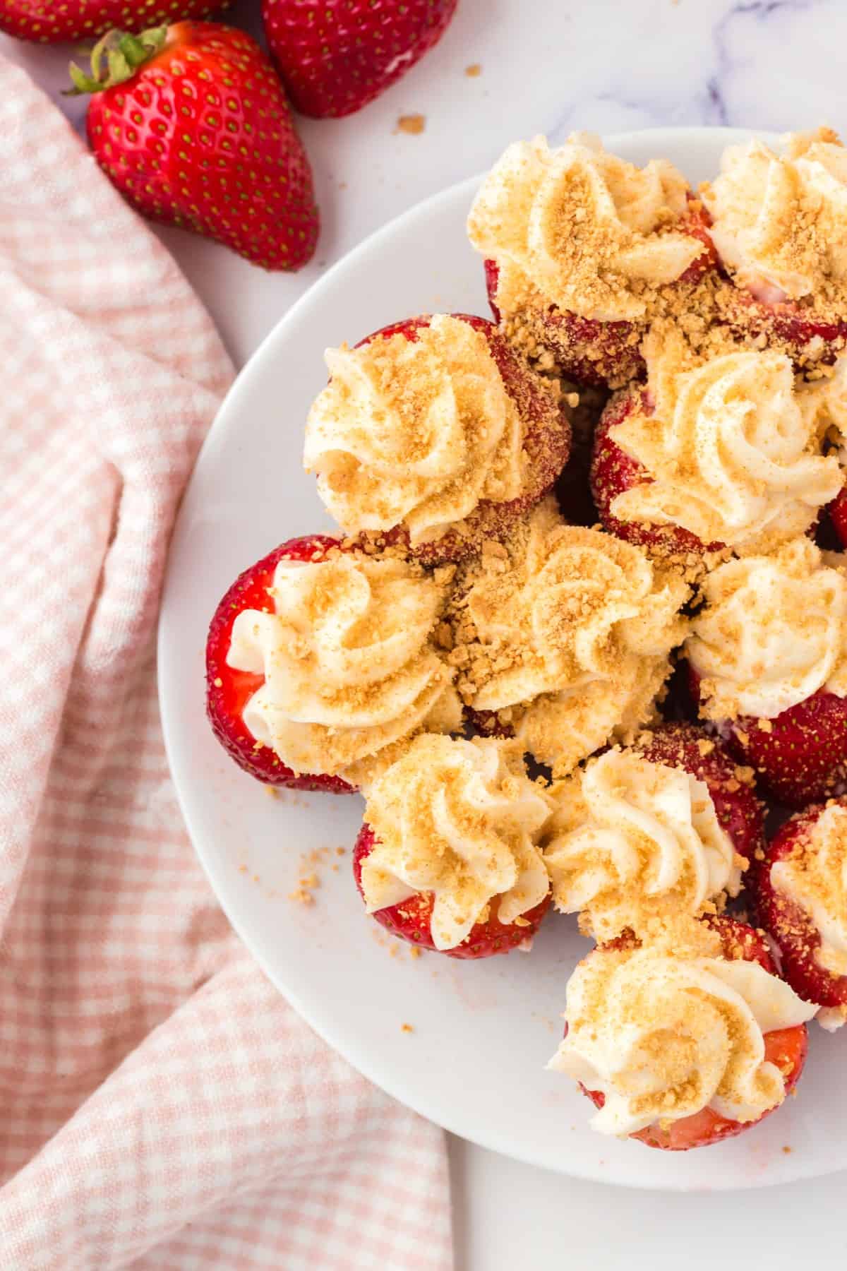 Overhead of stuffed strawberries on a plate, showing half the plate only. 