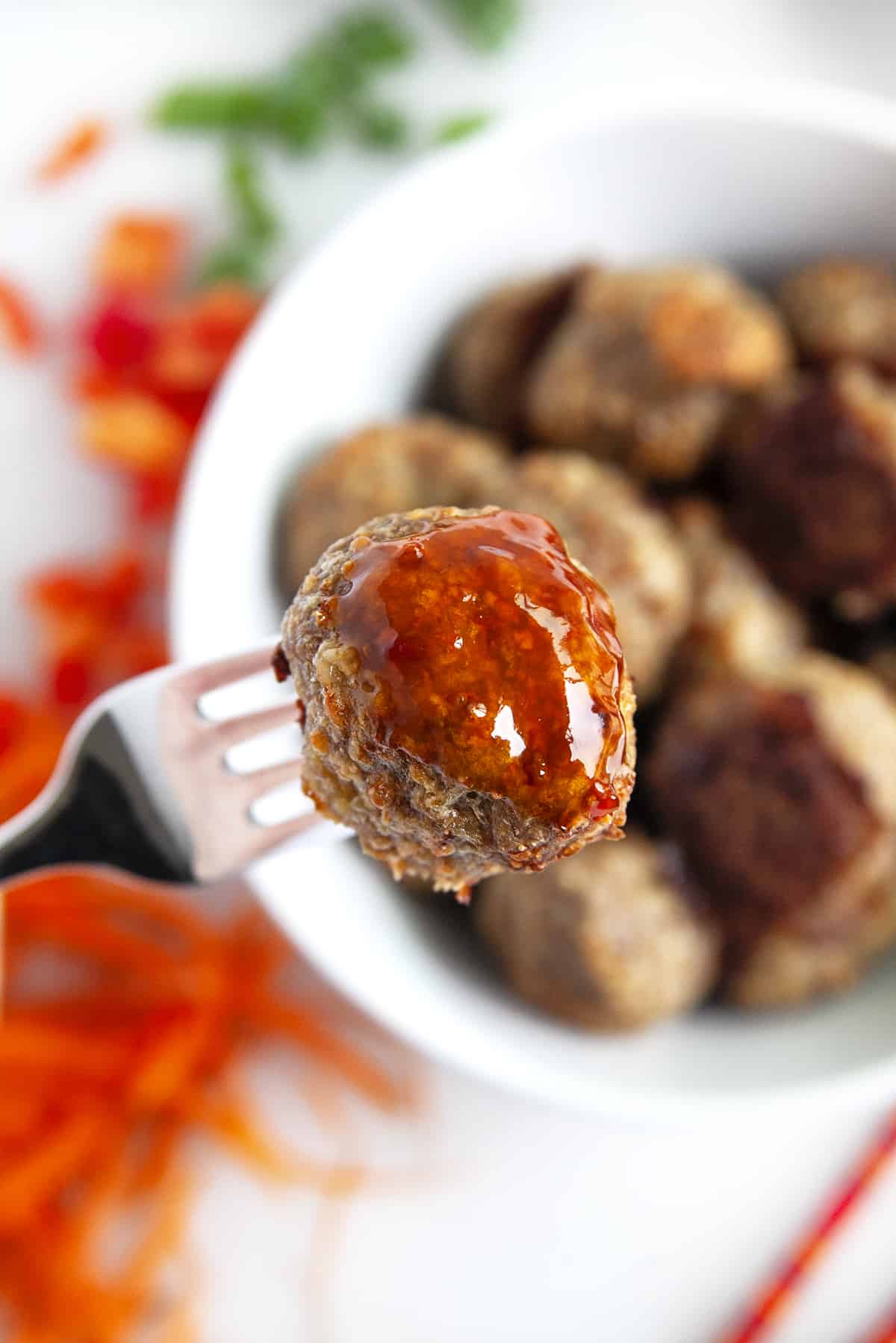 Sauced up meatball on a fork. 