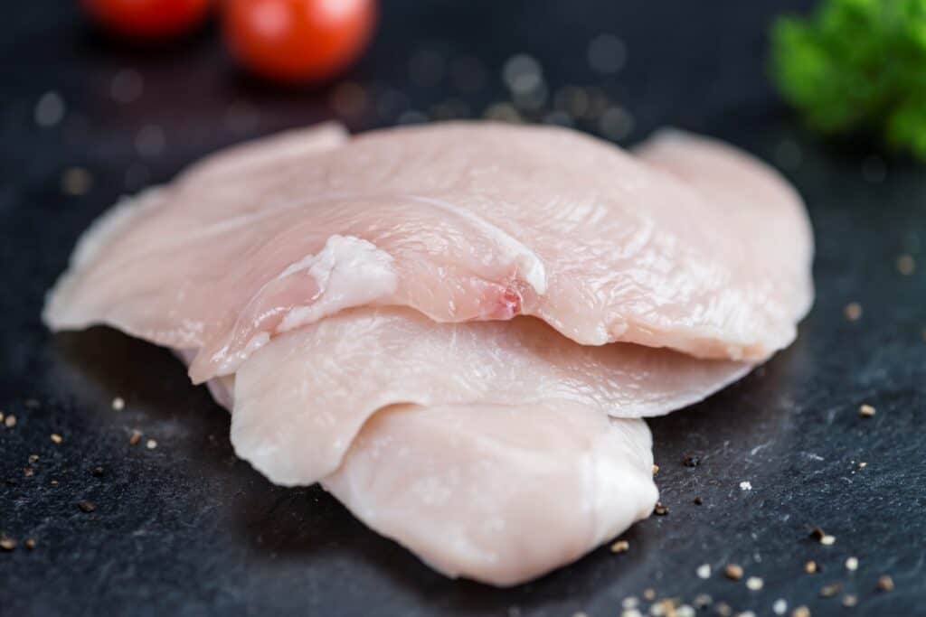 Raw Chicken Cutlet on a slate slab (detailed close-up shot)