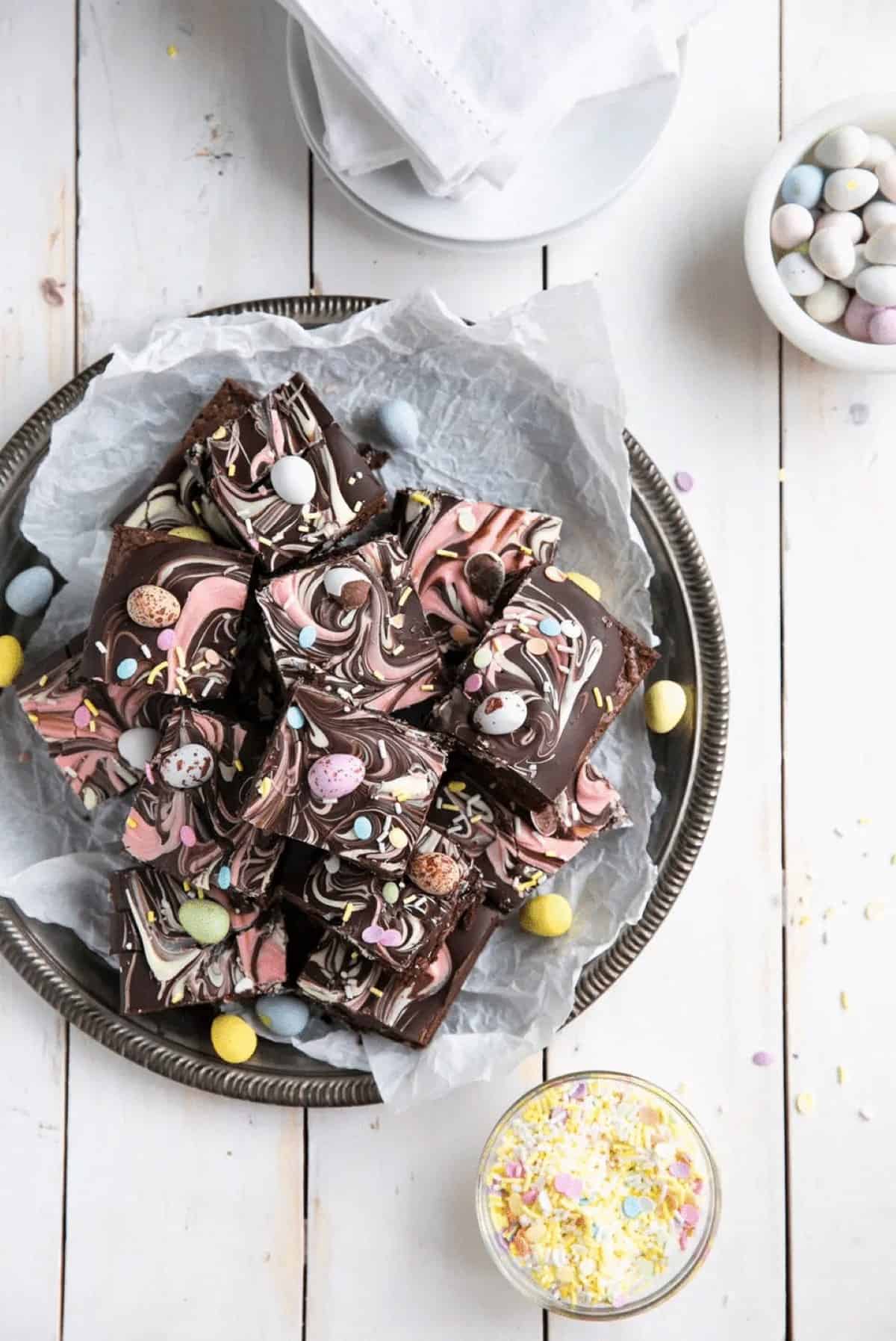 Chocolate bark Easter brownies stacked on a plate, shot from overhead. 