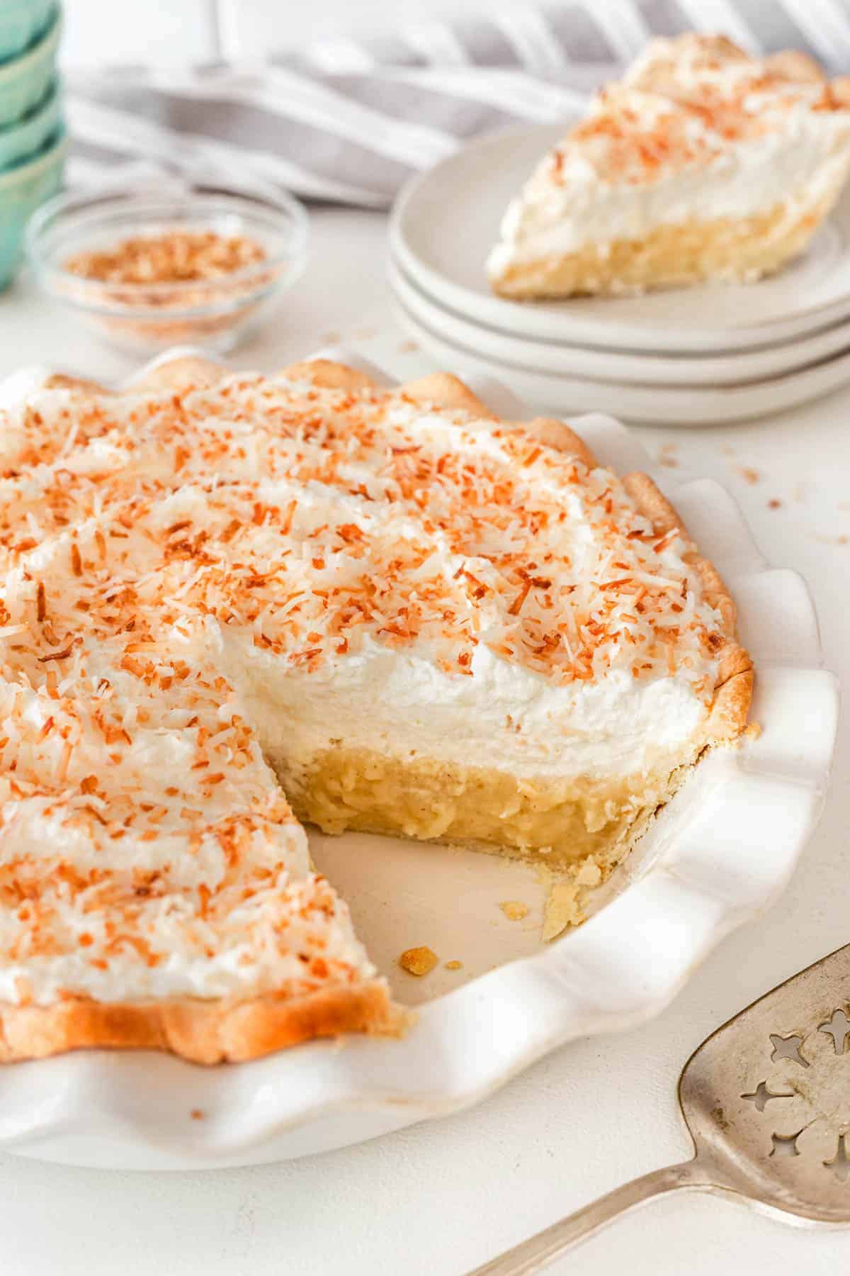 Coconut cream pie with a slice removed. 