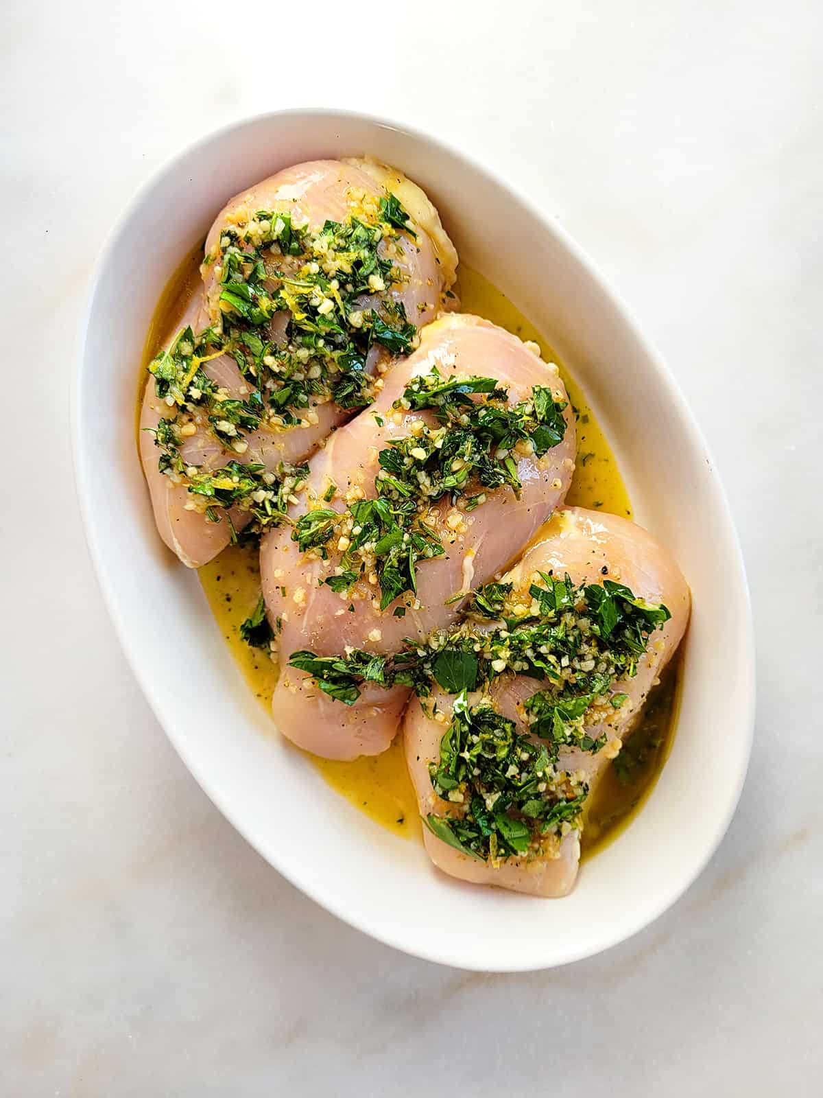 Three chicken breasts in marinade. 